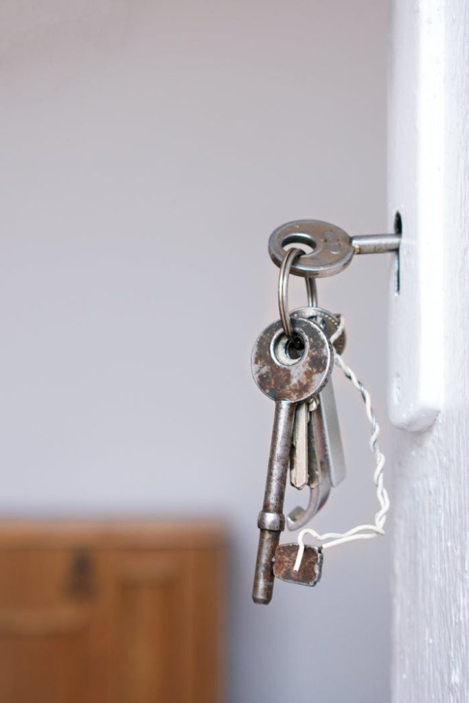 pexels photo 1405724 Close-up of vintage keys in a door keyhole with rustic metal and wood textures.